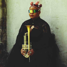 Black woman with sunglasses and crown with trumpet sitting on lap.